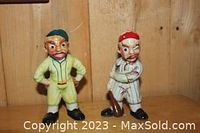 Photo of two vintage porcelain baseball player figurines against wooden background.