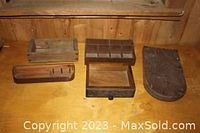 Group photo of four wooden boxes and drawers placed on wooden surface against wood wall