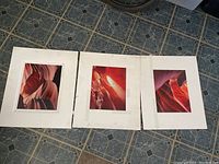 Three mounted photographic prints of Arizona Wave rock formations on floor showing detailed sandstone patterns in warm tones.