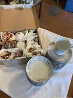 Photo of boxed set wrapped in packing materials showing 9 ice cream bowls and 9 cups and saucers set partially visible all in matching design.