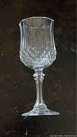 Single clear crystal wine goblet on dark background showing detailed cut glass design on bowl and decorative stem.