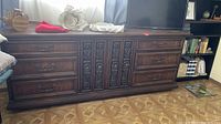 Full view of the vintage dresser showing the layout with six drawers and two cabinet doors, ornate carvings and wood grain visible.