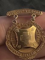 Close-up of front side showing the engraved texts and design details on the 10k gold pin.