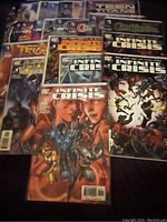 Photo showing a collection of D.C. Comics comic books including several issues from the Infinite Crisis series, Teen Titans, and other titles neatly arranged showing cover art.