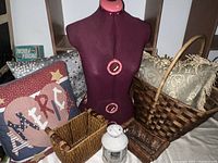 Overall view of the lot showing dress form, three pillows, three baskets, and a lantern on a shelf.