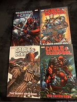 Four Marvel comic books featuring Cable and Deadpool characters laid out together showing front covers.