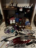 Wide view of multiple kitchen utensils, appliances, cutlery, decor items arranged on shelves and surfaces.