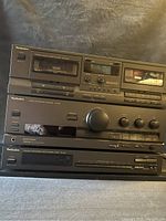 Photo showing three stacked Technics stereo components: double cassette deck, integrated amplifier, and AM/FM stereo tuner.