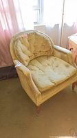 Full view of one Henredon accent chair showing tufted back, cushioned seat, and general wear on upholstery.