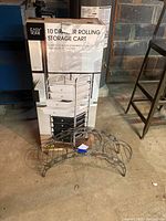 Boxed rolling storage cart with images of the 10 drawers and metal wire plant stand in front.
