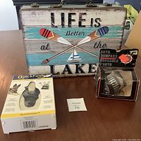 Lot contents including nail clippers in packaging, auto compass box, and decorative case showing text and graphics