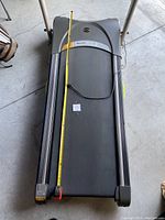 Top-down view of treadmill belt and deck with measuring tape across running surface