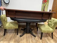 Side view showing stained wood shelf mounted on black round table surface, highlighting thickness and molding detail