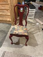 Front view of painted wooden chair with floral upholstered seat showing condition and damage