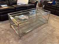 Front right perspective showing glass top, lower shelf, and casters