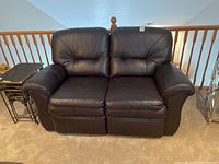 Front view of brown leather La-Z-Boy loveseat showing the two separate cushions and reclining footrests.