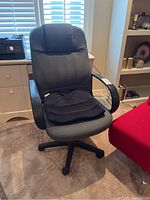 Front view of gray fabric office chair with black cushioned seat placed on it.