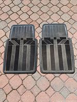 Photo showing front pair of black rubber auto floor mats with angled and straight groove pattern, designed for trucks and SUVs.