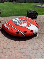 Photo of the Connelly Convertible inflatable water tube lying flat on a brick patio, showing overall condition and color pattern.