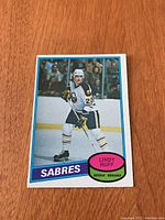 Front view of 1980/81 O-Pee-Chee Lindy Ruff rookie hockey card showing player photo, position, team, and name.