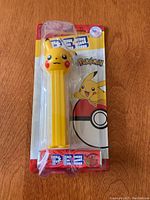 Front view of the new Pokemon Pikachu PEZ dispenser in sealed original packaging showing cartoon Pikachu and Pokeball background.