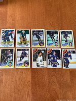 10 vintage Buffalo Sabres hockey cards laid out on wood surface, showing front sides with player images and names