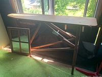 Side view of the antique pine ironing board showing structure and foldable legs.