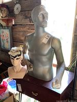 Male torso mannequin with clenched fists and detailed face including beard and mustache, placed on wooden table