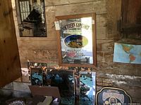 Photo of Southern Comfort mirrored print with wooden frame and Jack Daniels litho tray partially visible below it, on rustic wooden wall.