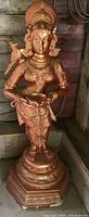 Full view of the statue showing the Indonesian woman with bird detail and the bowl she is holding.