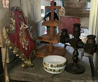 Photo showing wood framed mirror, tiered tray, vintage wall art with brass figure, melamine bowls, and wood candle holder.