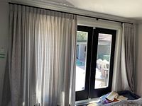 Curtains hanging over a set of double doors, showing length and coverage.