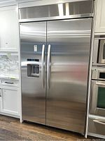 Full front view of stainless steel side-by-side refrigerator in kitchen setting