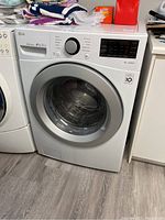 Full front view of LG front-load washer showing door, control panel and top surface