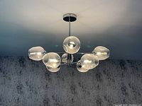 Overall view of the fixture installed on the ceiling showing eight evenly spaced glass globes
