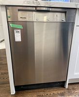 Front view stainless steel exterior with Miele Diamante branding and lot sticker