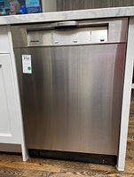 Front view of stainless steel dishwasher installed under countertop