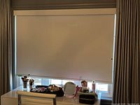 Full view of the roller blind fully lowered covering a window with a valance at the top.
