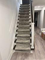 Full stairway covered with gray patterned runner carpet showing total length and width fitting stairs.
