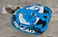 Inflatable tube laid flat with braided tow rope in plastic bag