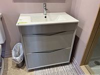 Front view of grey cabinet with integrated sink and faucet