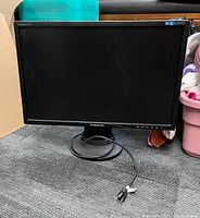 Samsung SyncMaster 2243 monitor shown powered off, front view on carpeted floor. Includes base stand and power cable.