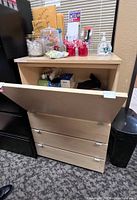 File cabinet with downward-opening drawer open showing interior space with various small items
