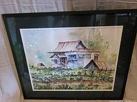 Front view of the framed watercolor painting showing the house and landscape scene.