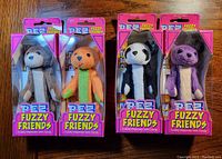 Front view of four new in box Pez Fuzzy Friends candy dispensers