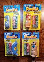 Front view of four sealed Pez Petz Series 2 dispensers with bubble gum, showing animal-themed dispensers: cat, dog, whale, kangaroo.