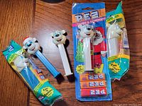 Photo showing five Polar Bear PEZ dispensers, with three still in original packaging and two opened dispensers without packaging, along with three PEZ candy packs.