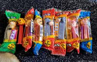 Eight PEZ dispensers featuring Winnie The Pooh characters, seven remain unopened in original packaging, one opened.
