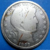 Obverse of the Barber Half Dollar showing Liberty's profile with date 1899 and In God We Trust inscription and stars.