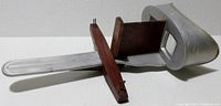 Side angle view of the 1904 Perfecscope stereoscope showing the metal body, wooden card holder, and wooden handheld handle.
